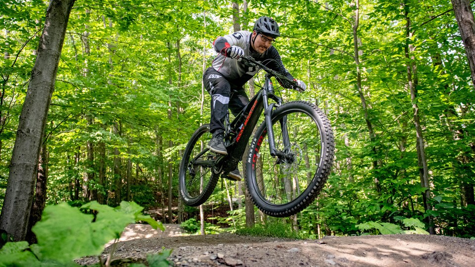 Le maire de Sherbrooke, Steve Lussier, fait un saut avec son vélo de montagne sur une piste du mont Bellevue.