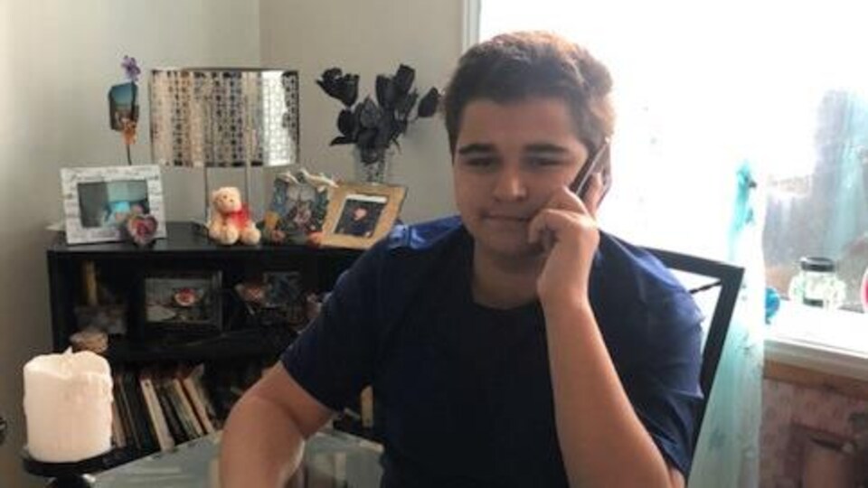 Un adolescent parle au téléphone.