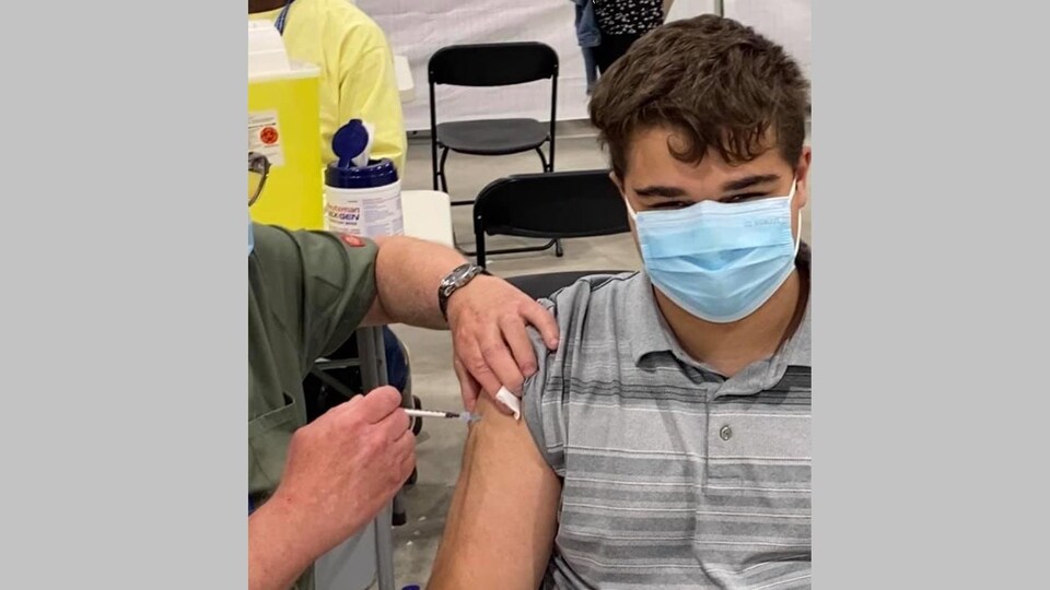 Steven Bilodeau avec un masque, qui se fait vacciner.