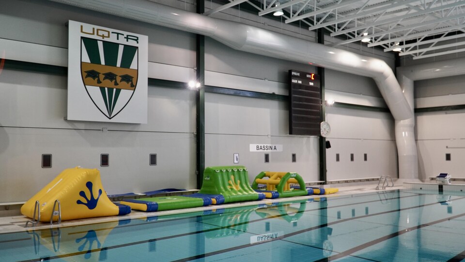 Des structures gonflables sont entreposés sur le bord de la piscine.