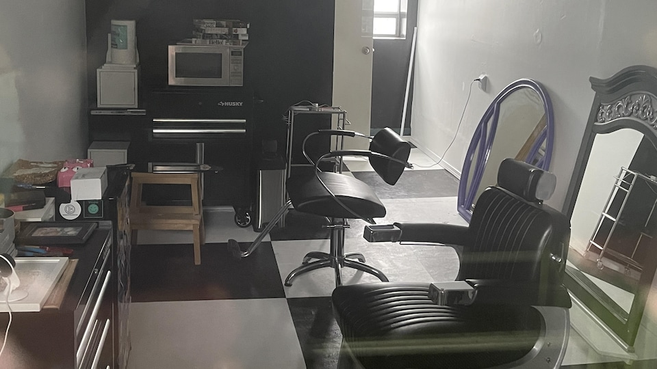 Un studio dans lequel se trouvent divers meubles dont deux chaises de barbier.