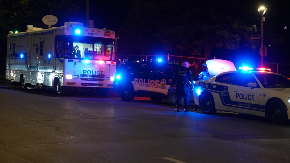 Trois véhicules de police sont immobilisés, le soir.