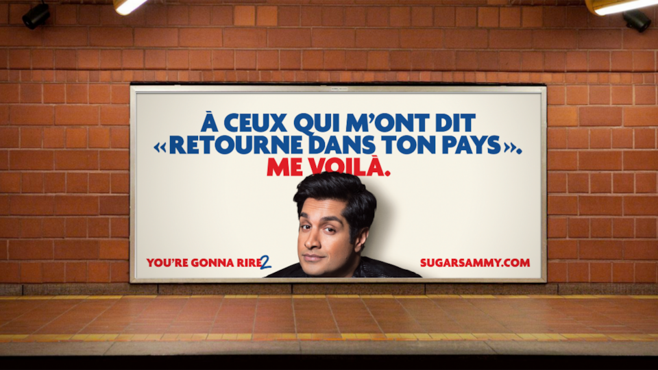 Une affiche de l'humoriste sur un mur du métro de Montréal et sur la quelle on peut lire : À ceux qui m'ont dit Retourne dans ton pays. Me voilà. »