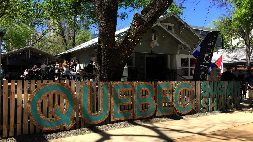 Une clôture sur laquelle on peut lire Quebec Sugar Shack, qui constitue la maison du Québec à Austin, au Texas, pour le festival SXSW.