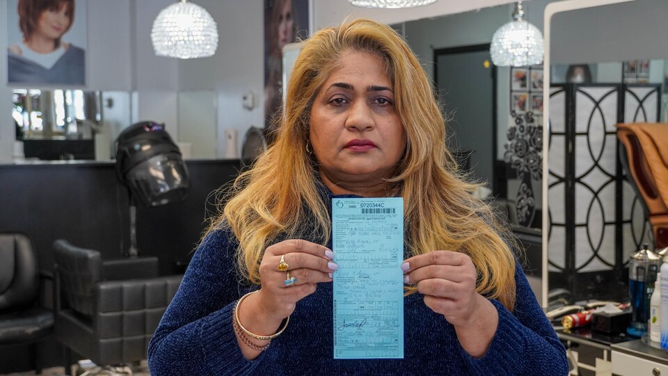 La femme tient dans ses mains la contravention.