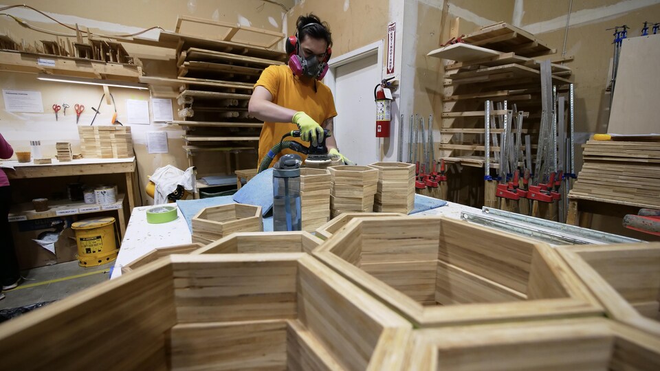 Un ouvrier polit des boîtes faites de baguettes de bambou.