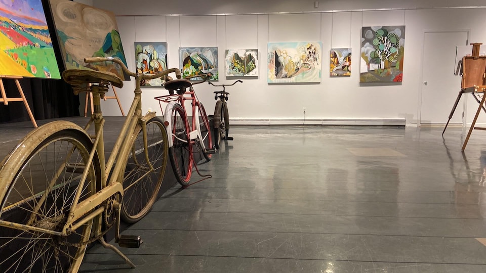 Des toiles sont accrochées au mur et des vélos sont peints. 