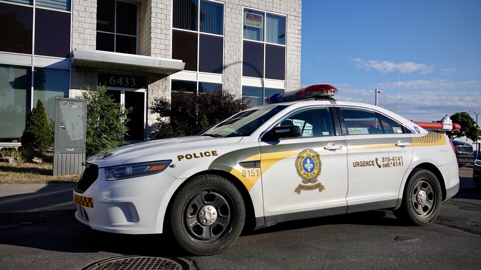 Une voiture de police devant un immeuble.