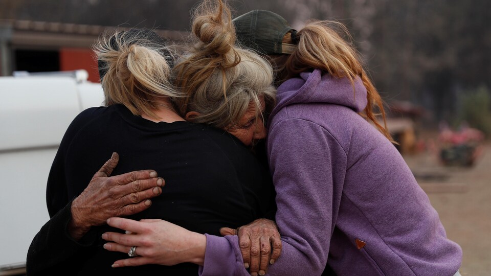 Cathy Fallon, restée à Paradise pour s'occuper de ses chevaux pendant l’incendie de 2018, embrasse Shawna De Long et April Smith.