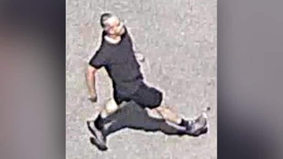 Un homme habillé en noir marche dans la rue.