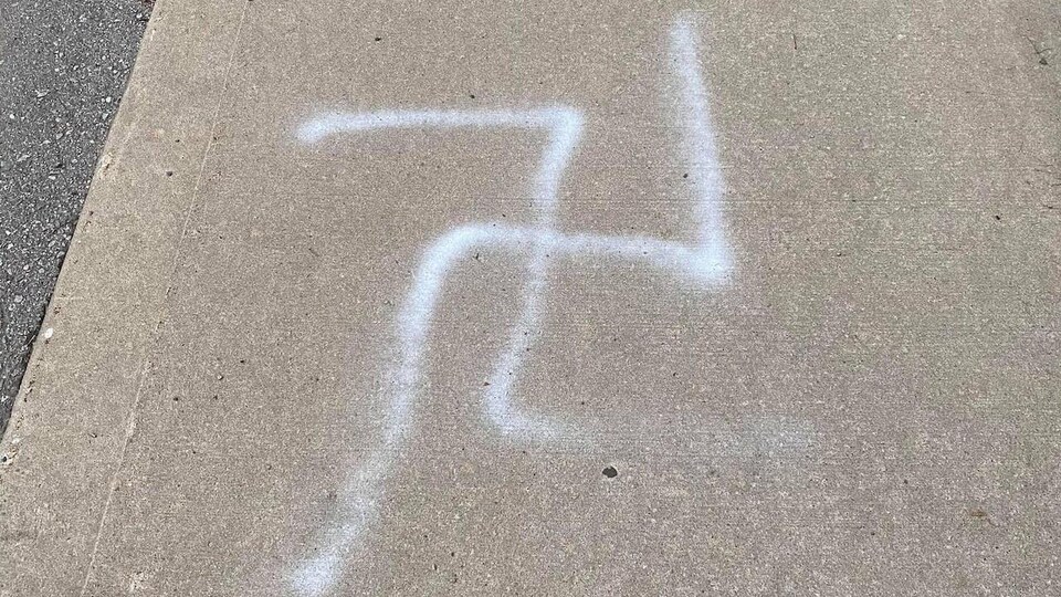 Une croix gammée peinte sur le trottoir.