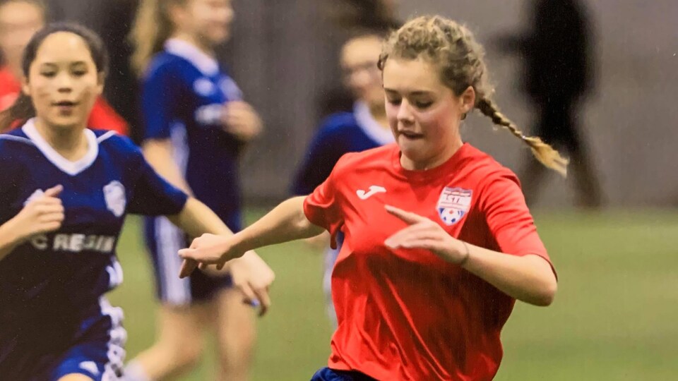 Deux filles cours lors d'un match de soccer.