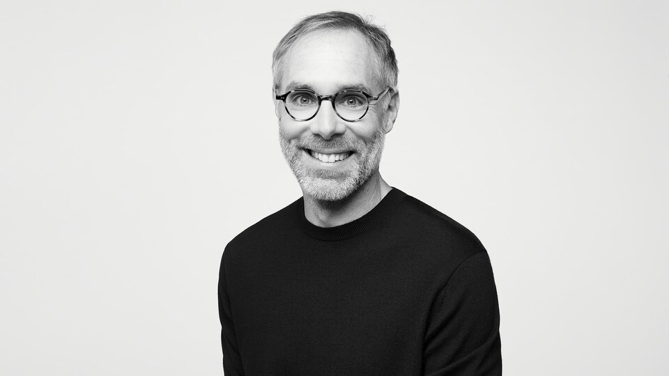Portrait en noir et blanc d'un homme qui porte des lunettes. 