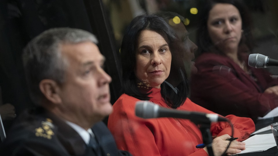 Trois personnes assises derrière des micros durant une conférence de presse.