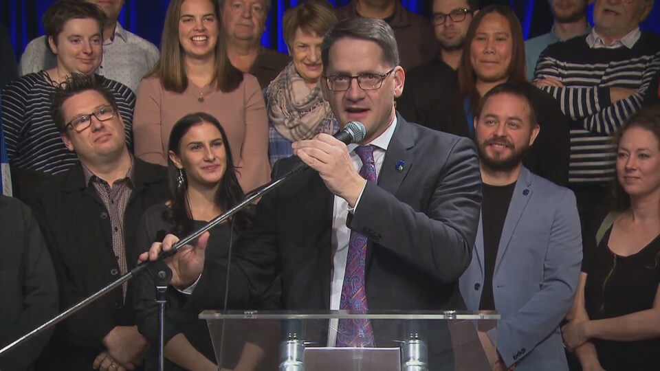 Le député de Jonquière, Sylvain Gaudreault, au micro, devant ses militants.