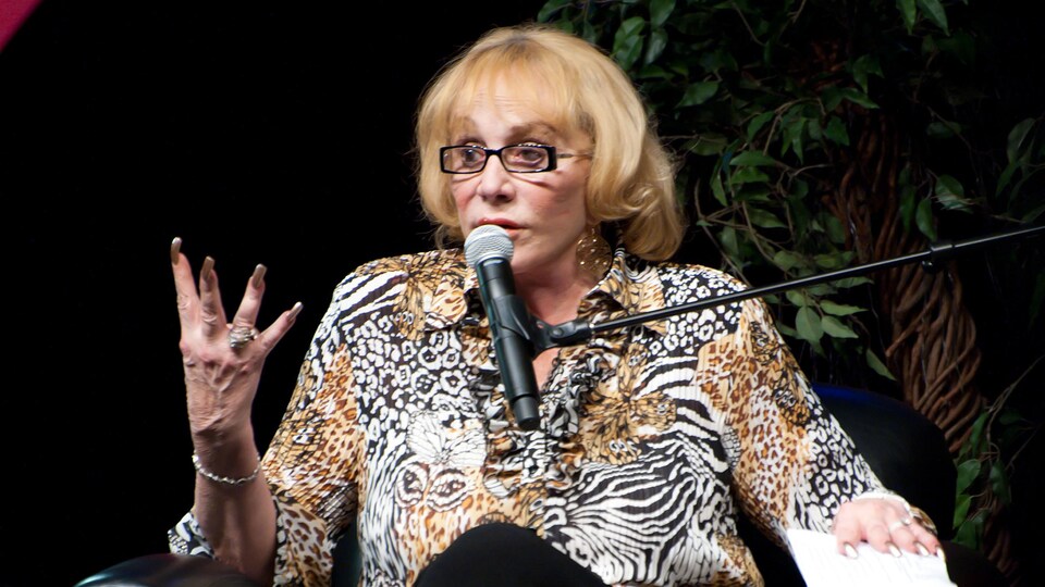 Sylvia Browne parle dans un microphone.