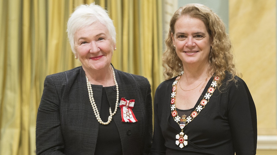 Deux dames, Sylvia L'Écuyer et Julie Payette se sert la main et pause de face.