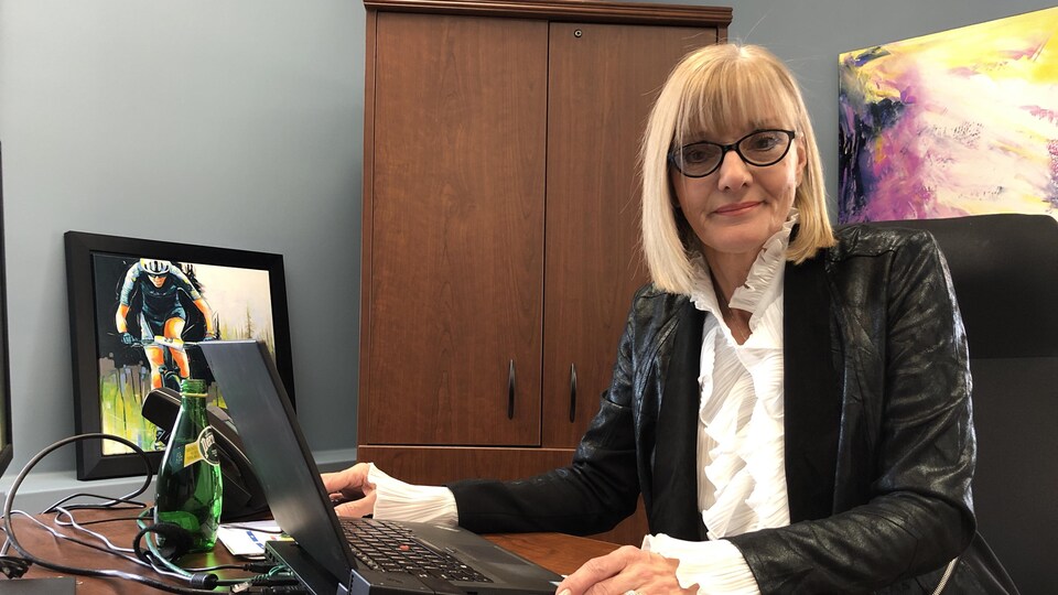 Une femme assise derrière un bureau.