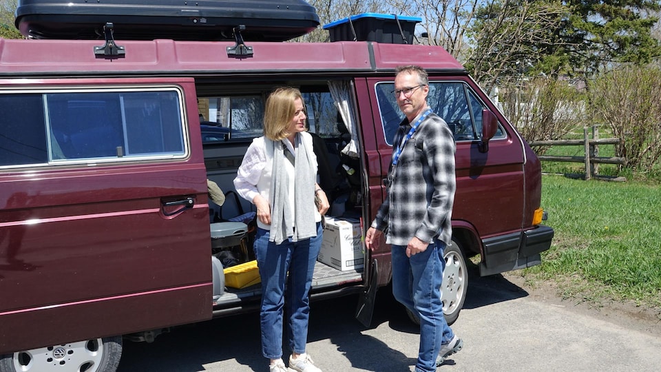 A couple is camping in their minivan.