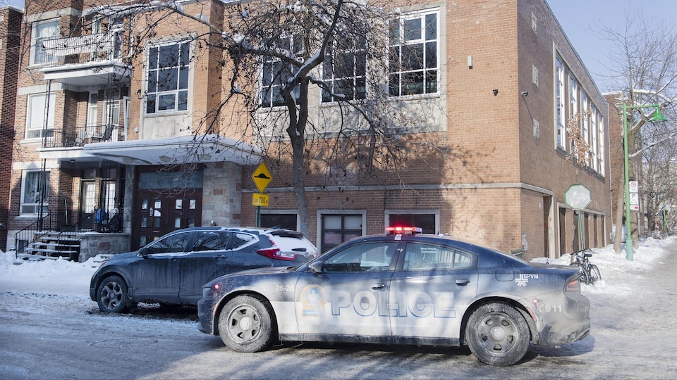 Une voiture de police stationnée devant une synagogue.