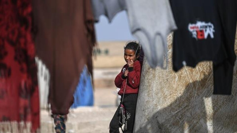 Une jeune Syrienne à l'extérieur d'une tente, dans un camp de réfugiés.