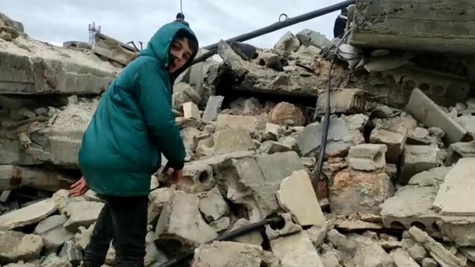Un garçon grimpe sur un tas de décombres après un puissant tremblement de terre en Syrie.