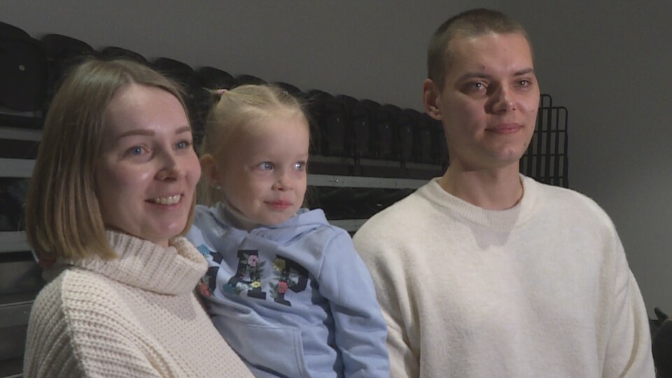 Dmytro et Anastasia Syrman ainsi que leur fille de 4 ans regardent la caméra.
