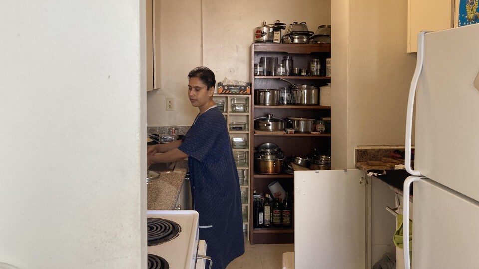 Tahmina Ahmed fait la vaisselle dans son appartement.