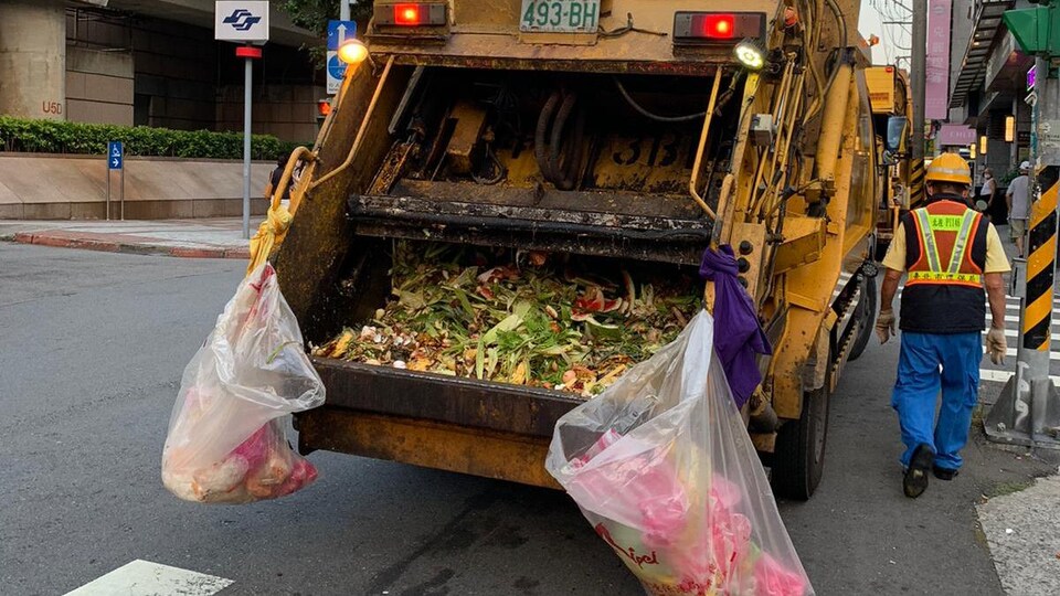 Un éboueur marche près de son camion.