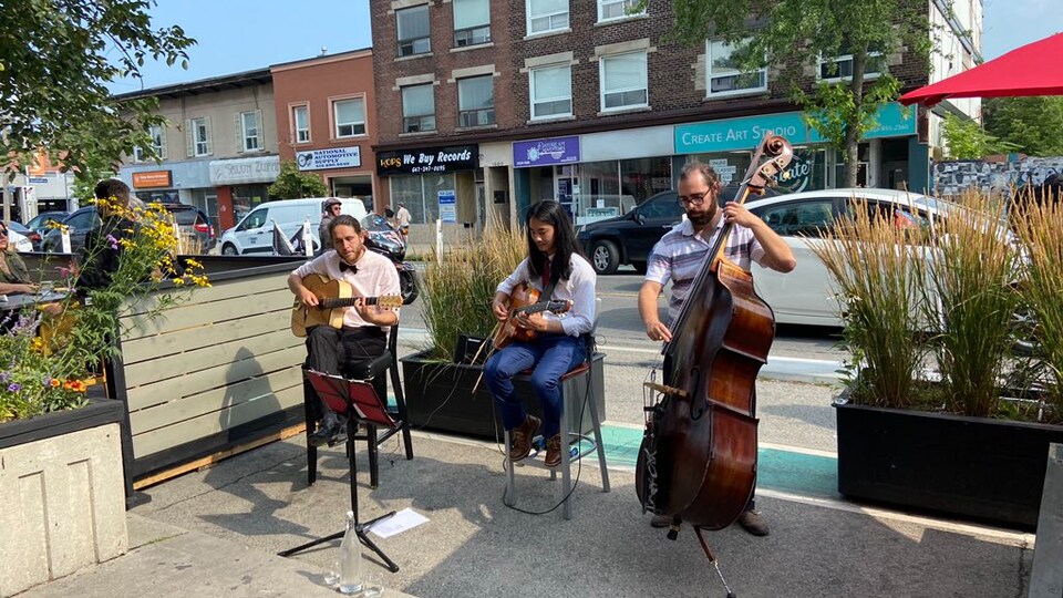 Le Tak Arikushi Trio joue sur une terrasse.