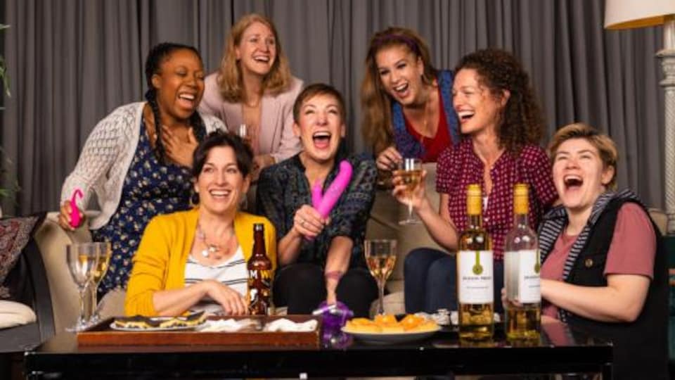 Sept femmes rigolent sur un canapé.