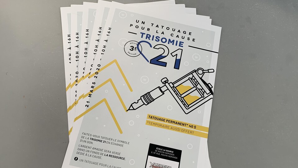 Des feuilles indiquant Un tatouage pour la trisomie 21. La feuille informe qui l'on peut se faire tatouer le symbole de la Trisomie 21 en échange d'un don.