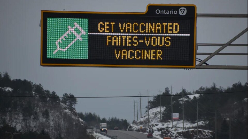 Une affiche sur la route invitant les Ontariens à se faire vacciner contre la COVID-19.