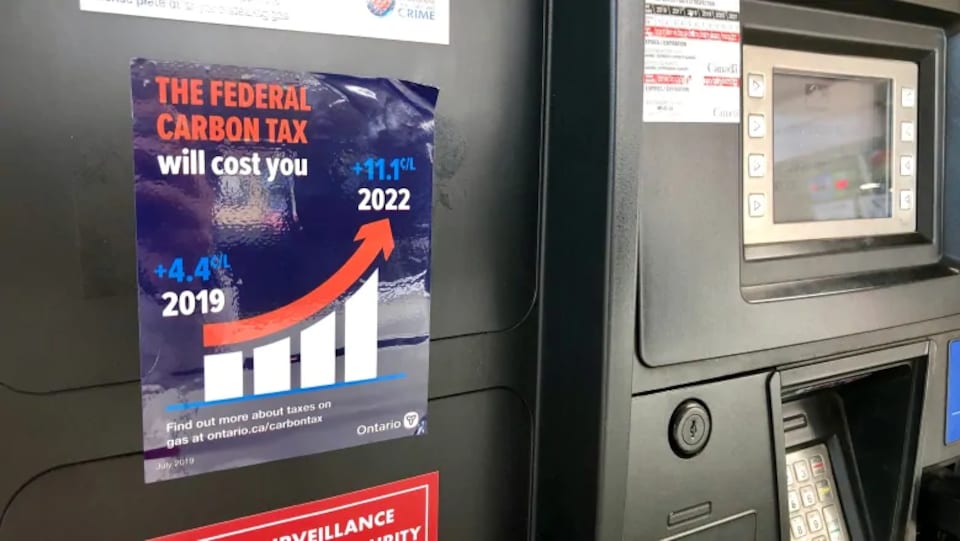 Un autocollant apposé sur une pompe à essence et dont le coin supérieur droit se décolle.