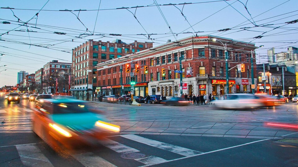 A taxi is driving on Spadina Avenue in downtown Toronto.