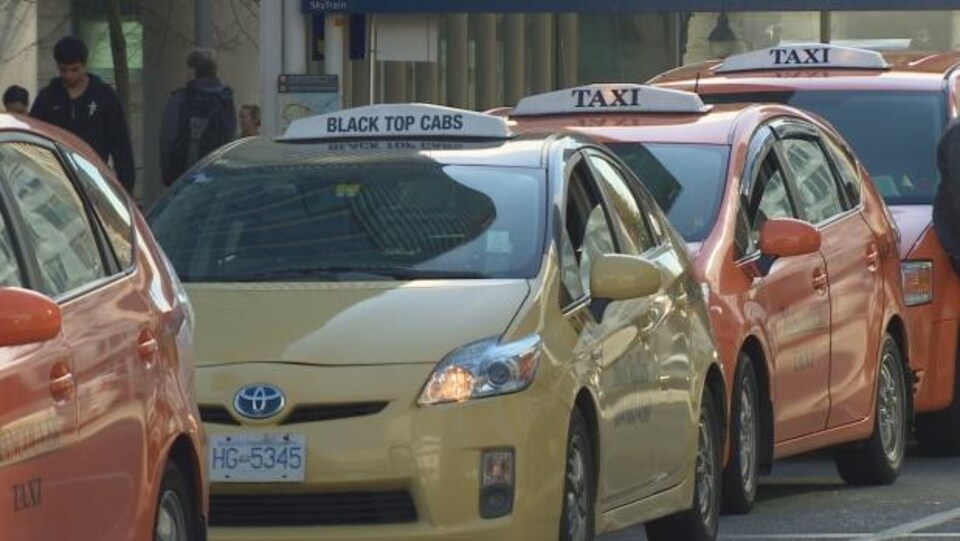 Quatre taxis l'un à la suite de l'autre.