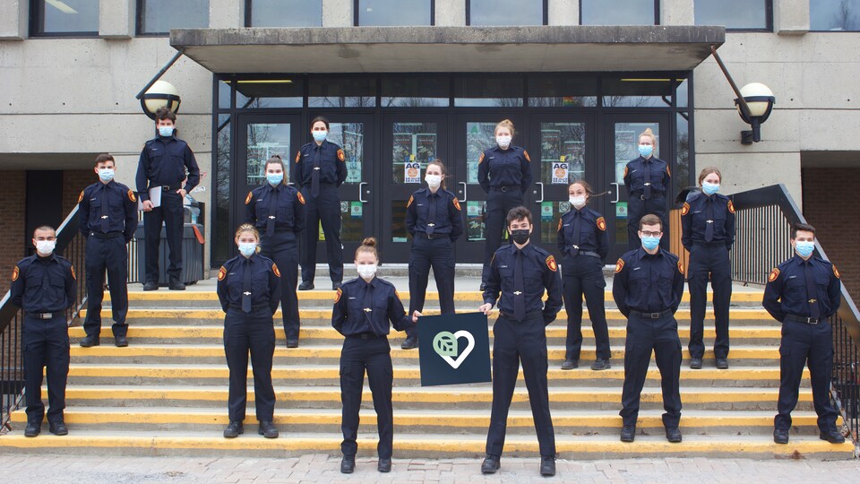 Une quinzaine d'étudiants habillés en uniforme bleu foncé