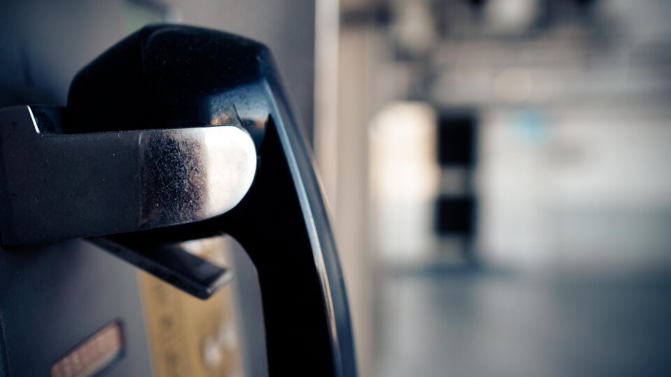 Plan rapproché du combiné d'un téléphone public.