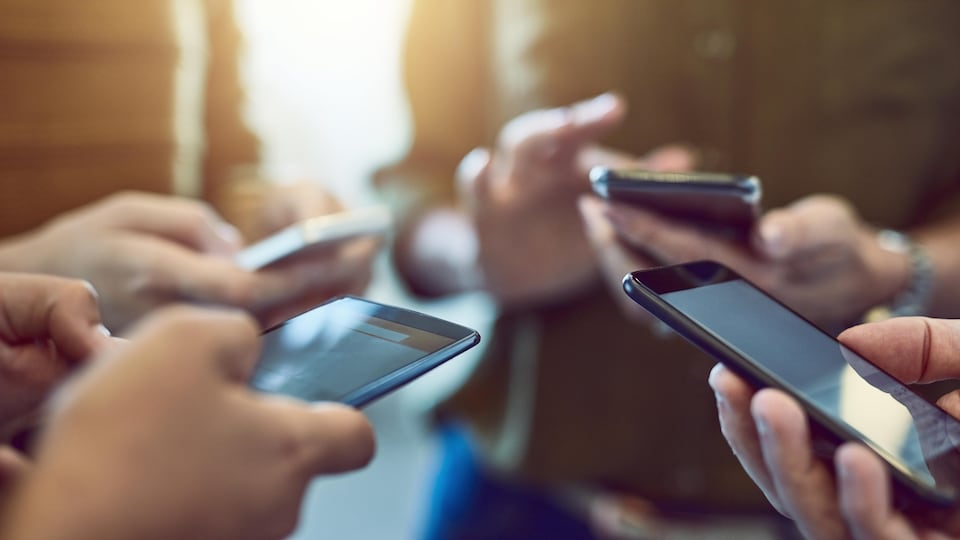 Des gens utilisent leur téléphone intelligent.