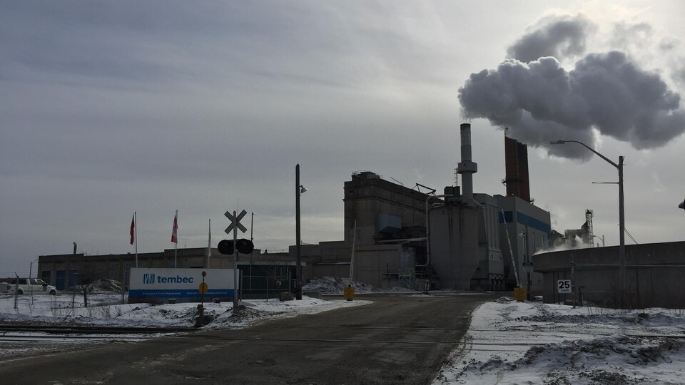 L'usine vue en hiver. Un nuage de fumée s'échappe de la cheminée.