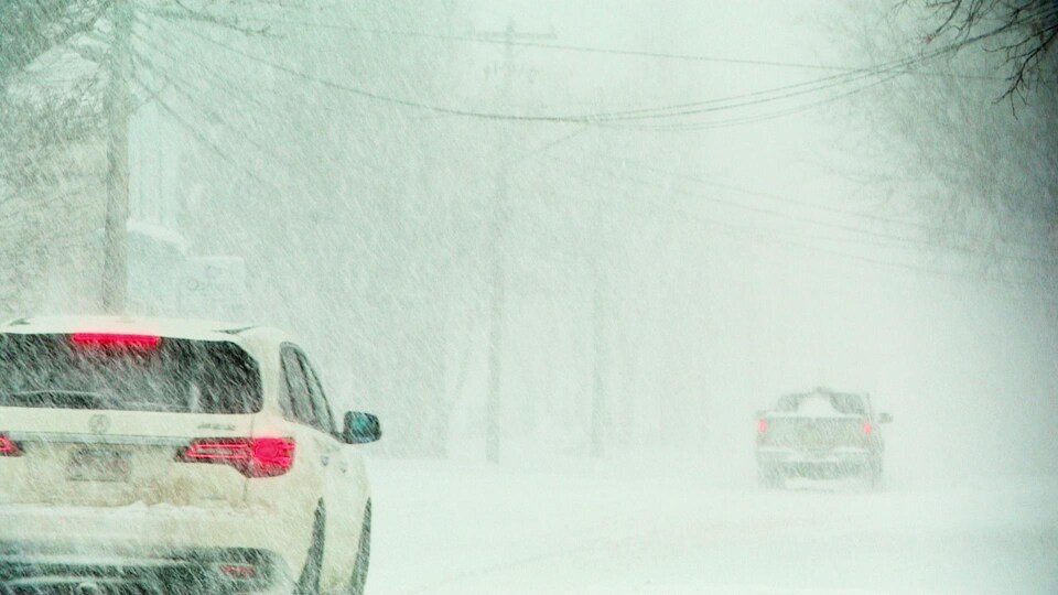 Des voitures sur une route enneigée.