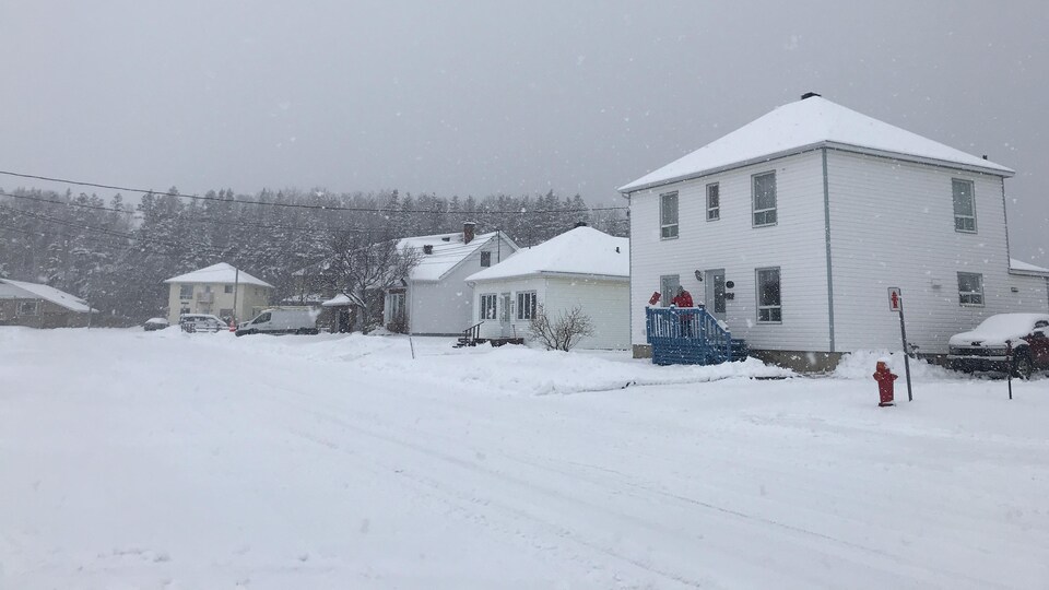 Une femme pellette sur sa galerie lors de la tempête de neige à Matane du 29 mars 2021.