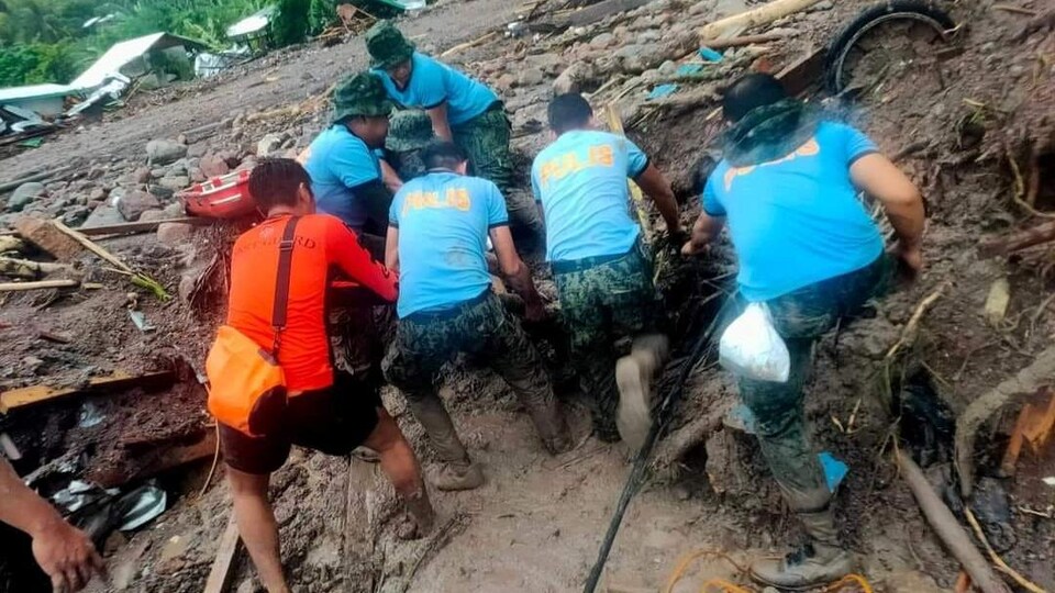 Des sauveteurs récupèrent un corps à la suite d'inondations et de glissements de terrain dans le village de Kusiong, situé dans le sud du pays. 