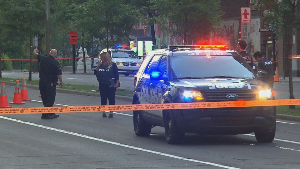 Des cordons policiers entourent des voitures de police sur le boulevard René-Lévesque, fermé.