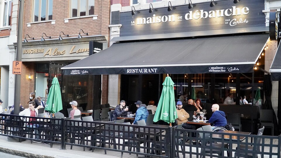Des personnes assises à une terrasse de restaurant.
