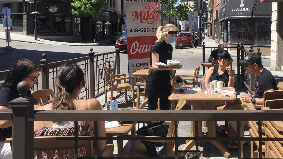 Des gens mangent sur une terrasse au centre-ville de Chicoutimi.