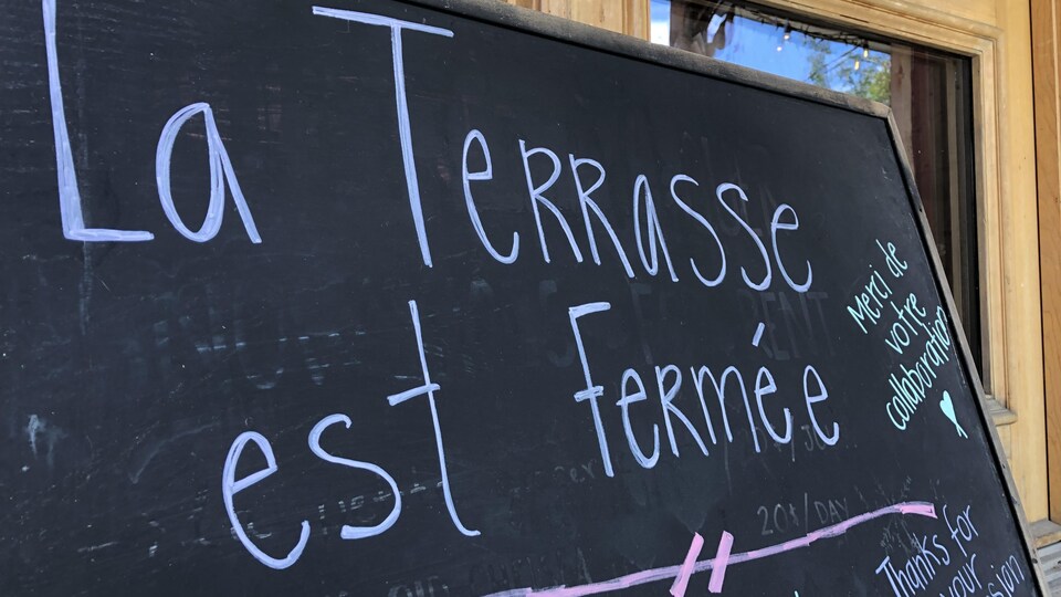 Une affiche indique que la terrasse d'un restaurant est fermée en raison des mesures sanitaires.