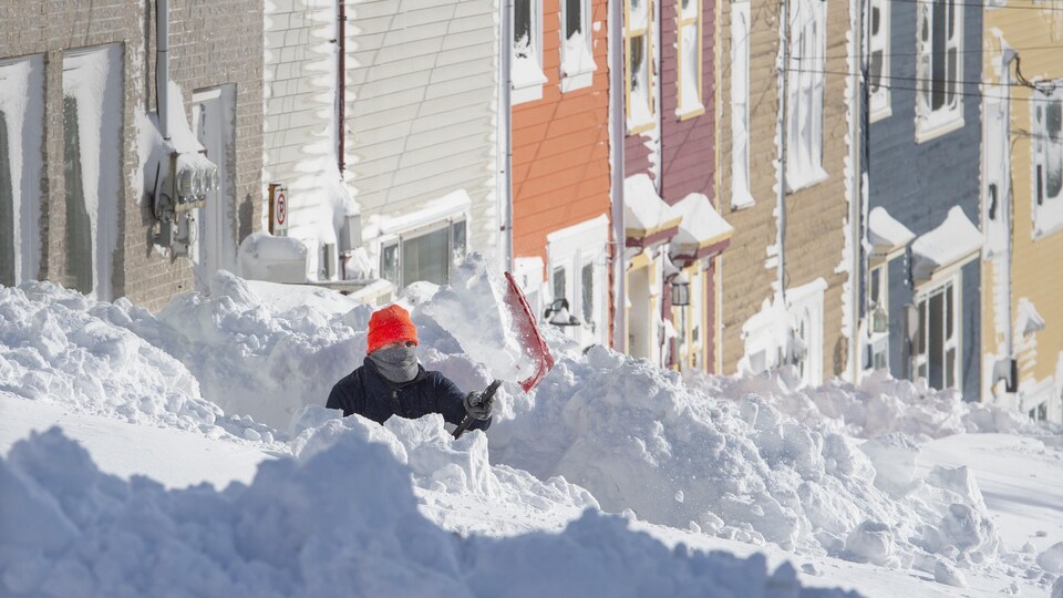Une personne est occupée à pelleter après le passage du blizzard, à Terre-Neuve.