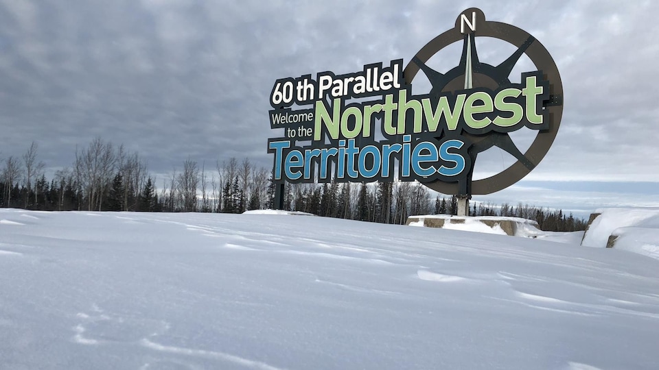 Enseigne des Territoires du Nord-Ouest dans un paysage d'hiver.