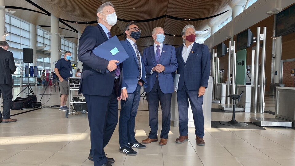Terry Duguid, Omar Alghabra, Barry Rempel et Dan Vandal, à l'aéroport de Winipeg.